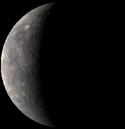 Una vista de Mercurio del Messenger en un vuelo anterior.  La imagen muestra los colores verdaderos del planeta.  Las pequeñas manchas brillantes son cráteres de impacto recientes, y algunas de las marcas más oscuras pueden ser evidencia de actividad volcánica reciente.  [NASA/JHUAPL]